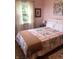 Bright bedroom features a floral-themed quilt, wood flooring, and a window that offers natural light at 21749 Oak Ridge Rd, Sheridan, IN 46069