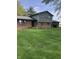 Charming two-story home with a brick facade and a spacious front yard, complemented by a rustic wooden fence at 21749 Oak Ridge Rd, Sheridan, IN 46069