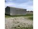 Silver storage building against a gravel area, bordering green grass and an agricultural field, offering ample outdoor storage at 21749 Oak Ridge Rd, Sheridan, IN 46069