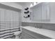 Well-lit bathroom featuring a gray vanity, shower with striped curtain and modern shelving at 2228 Dover St, Anderson, IN 46013