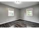 Cozy bedroom with gray walls, wood floors, and two windows providing natural light at 2228 Dover St, Anderson, IN 46013