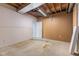 Unfinished basement with concrete floor and exposed wood ceiling and a white door to another room at 248 Runyon Ct, Greenwood, IN 46142