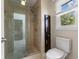 Bathroom featuring a glass shower, brown cabinet and a window looking out to the outdoors at 248 Runyon Ct, Greenwood, IN 46142