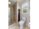 Bathroom featuring a glass shower, brown cabinet and a window looking out to the outdoors at 248 Runyon Ct, Greenwood, IN 46142
