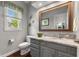 Well-lit bathroom with a gray vanity, marble countertop, and decorative mirror with a rustic wood frame at 248 Runyon Ct, Greenwood, IN 46142