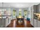 Eat-in kitchen with a table and 6 chairs under chandelier lighting next to white cabinets and light blue walls at 248 Runyon Ct, Greenwood, IN 46142