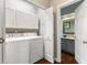 Laundry Room featuring a white washer and dryer set with white cabinets, coat hooks and a view into the bathroom at 248 Runyon Ct, Greenwood, IN 46142