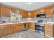 Contemporary kitchen showcasing stainless steel appliances, light wood cabinetry, and durable flooring at 2740 Braxton Dr, Indianapolis, IN 46229