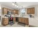 Well-lit kitchen with wood cabinets, stainless steel appliances, and a view of the backyard at 2802 Singletree Dr, Indianapolis, IN 46234