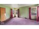 Bedroom with three windows offering natural light and dated magenta carpet at 2840 W 12Th St, Anderson, IN 46011