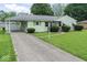 Quaint single-story home featuring a covered carport and mature landscaping at 2840 W 12Th St, Anderson, IN 46011