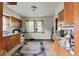 An outdated kitchen featuring wood cabinets, worn floors, and some natural light at 2840 W 12Th St, Anderson, IN 46011
