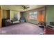 Spacious living room with a brick fireplace, large window and dated carpet in need of updating at 2840 W 12Th St, Anderson, IN 46011