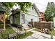 Backyard featuring patio area, green siding, metal chairs, and privacy fence at 309 N Riley Ave, Indianapolis, IN 46201