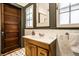 Bathroom featuring mosaic floors, a wooden vanity, and window above sink at 309 N Riley Ave, Indianapolis, IN 46201
