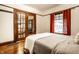 Bedroom featuring hardwood floors, window with red curtains, and white walls at 309 N Riley Ave, Indianapolis, IN 46201