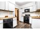 Updated kitchen with white cabinets, butcher block countertops, and black appliances at 309 N Riley Ave, Indianapolis, IN 46201