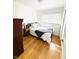 Bright bedroom featuring a queen-sized bed, a dark wood dresser, and gleaming hardwood floors at 3414 Rost Dr, Columbus, IN 47203