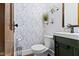 Charming powder room with floral wallpaper, dark green vanity, and glass shelving adding to the unique design at 344 N Whittier Pl, Indianapolis, IN 46219