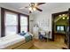 Comfortable bedroom with hardwood floors, ceiling fan, dresser, and a doorway leading to another room at 344 N Whittier Pl, Indianapolis, IN 46219