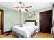 Inviting bedroom with light green walls, hardwood floors, ceiling fan and rustic accents at 344 N Whittier Pl, Indianapolis, IN 46219