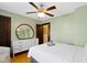 Cozy bedroom with ceiling fan, large oval mirror, white dresser and neutral decor at 344 N Whittier Pl, Indianapolis, IN 46219