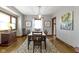 Traditional dining room featuring hardwood floors, a decorative rug, and updated light fixture with natural light at 344 N Whittier Pl, Indianapolis, IN 46219