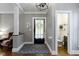 Bright foyer with hardwood flooring, a powder room, and a cozy armchair at 344 N Whittier Pl, Indianapolis, IN 46219