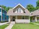 Charming craftsman home featuring a welcoming front porch and a well-manicured lawn at 344 N Whittier Pl, Indianapolis, IN 46219