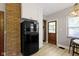 Charming kitchen featuring a vintage black refrigerator, brick accent wall, and updated cabinets at 344 N Whittier Pl, Indianapolis, IN 46219