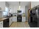 Bright kitchen featuring white cabinets, black appliances, butcher block countertops, and modern fixtures at 344 N Whittier Pl, Indianapolis, IN 46219