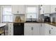 Updated kitchen showcasing white cabinets, black hardware, butcher block counters, and stainless steel sink at 344 N Whittier Pl, Indianapolis, IN 46219