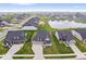 An aerial view showcasing a pond and modern homes in a well-kept neighborhood with manicured lawns at 3463 Sunnyvale Dr, Brownsburg, IN 46112