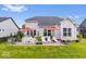 Backyard features a well-maintained lawn and a paved patio with outdoor furniture, dining area, and garden at 3463 Sunnyvale Dr, Brownsburg, IN 46112