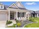 Cozy front porch with white chairs, perfect for relaxing, complemented by beautiful landscaping and a stone walkway at 3463 Sunnyvale Dr, Brownsburg, IN 46112