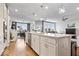 Modern kitchen island with stone countertops, seating, and stainless steel sink, blending seamlessly into the open living space at 3463 Sunnyvale Dr, Brownsburg, IN 46112