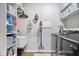 Well-organized laundry room with front-load washer/dryer, storage cabinets, utility sink, and space-saving wall-mounted vacuum at 3463 Sunnyvale Dr, Brownsburg, IN 46112