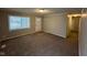 Open living room with neutral walls, carpet, and bright natural light through a large window at 3742 N Wittfield St, Indianapolis, IN 46235
