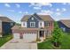 Beautiful two-story home with a brick and blue facade, well-manicured lawn, and a three-car garage at 3948 Saddle Club S Pkwy, Bargersville, IN 46106