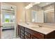 Bright bathroom with double vanity, granite counters and views into primary bedroom and tiled walk-in shower at 4367 Homestead Dr, Whitestown, IN 46075