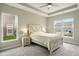 Cozy bedroom with neutral tones, carpet, a ceiling fan, large windows and a rustic farmhouse-style bed at 4367 Homestead Dr, Whitestown, IN 46075