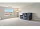 Inviting bonus room featuring neutral carpet, natural light and a comfortable gray love seat at 4367 Homestead Dr, Whitestown, IN 46075