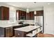 Contemporary kitchen featuring stainless steel appliances, dark wood cabinets, and a bright white island at 4367 Homestead Dr, Whitestown, IN 46075