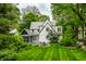 Lush green backyard with mature trees surrounding a charming home with a screened-in porch at 4410 N Pennsylvania St, Indianapolis, IN 46205