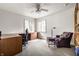 Bright bedroom boasts a ceiling fan, two windows, a desk, and a comfortable purple chair at 4410 N Pennsylvania St, Indianapolis, IN 46205