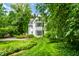 Charming white two-story home surrounded by lush green lawn and mature trees at 4410 N Pennsylvania St, Indianapolis, IN 46205