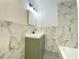Stylish bathroom featuring a green vanity with sleek black fixtures and marble-patterned walls at 453 Illinois St, Fortville, IN 46040