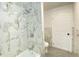 Modern bathroom featuring elegant marble tiling and a bathtub with contemporary fixtures at 453 Illinois St, Fortville, IN 46040