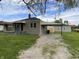 Back view of home with car port and garage, a spacious gravel driveway, and a well-kept yard at 453 Illinois St, Fortville, IN 46040