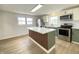 Bright kitchen featuring an island with sleek countertop, white cabinetry, and modern appliances at 453 Illinois St, Fortville, IN 46040